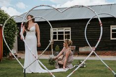 the bride and her mother are making a heart - shaped frame out of paper streamers