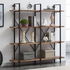 a book shelf with books and vases sitting on top of it next to a chair