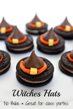 chocolate covered cookies with orange and black decorations on top, sitting on a white plate