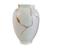 a white and gold vase sitting on top of a table