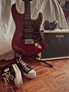 an electric guitar and some shoes on the floor