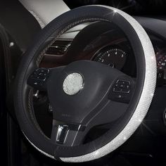 the steering wheel cover is black and white with silver stitching on it's sides