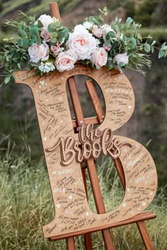 a wooden easel with flowers and writing on it