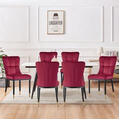 a dining room table with red chairs and a rug on the floor in front of it