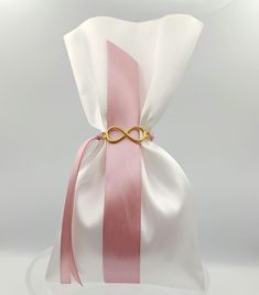 a pink and white bag with a gold ring on it