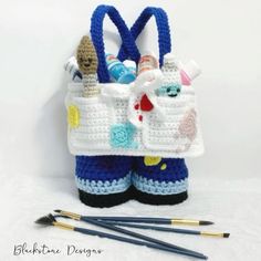 a crocheted bag with scissors and knitting needles