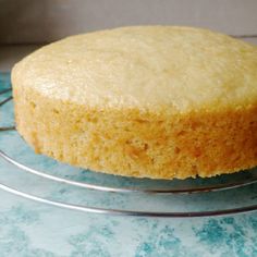 a round cake sitting on top of a metal rack next to a blue countertop