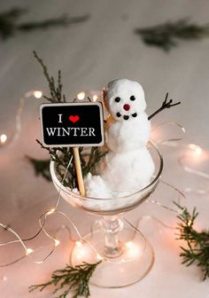 a snowman in a glass bowl with a sign that says i love winter