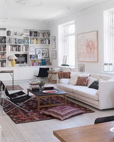 a living room filled with lots of furniture and bookshelves on top of each other