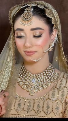 a woman wearing a bridal outfit and jewelry