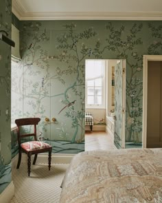 a bedroom with green wallpaper and a chair in the corner