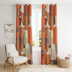 a living room with a chair, rug and window curtain in front of the window