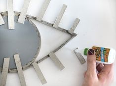 a person is painting a metal clock on the wall