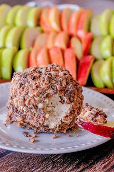 an apple dessert is on a plate with apples in the background