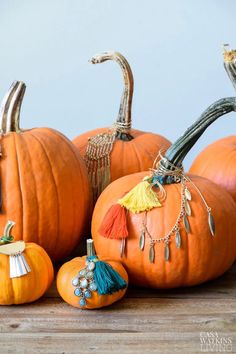 several orange pumpkins with tassels on them sitting on a table next to each other