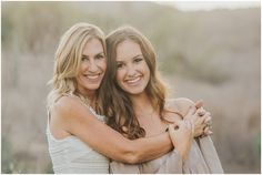 two beautiful women hugging each other in a field