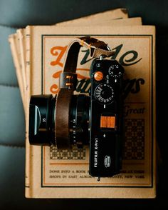 an old camera sitting on top of a book