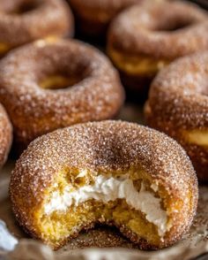 there are many donuts with icing and powdered sugar on the top one is cut in half