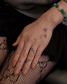 a woman's hand with a tattoo on it and some fish netted stockings