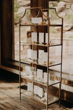 a display case filled with lots of cards on top of a wooden floor next to a window