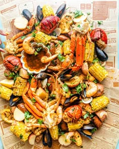 a platter filled with seafood and corn on the cob is pictured in this image