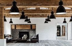 a living room filled with furniture and lots of lights hanging from the ceiling next to a fire place