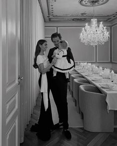 a man and woman standing next to each other in front of a dining room table