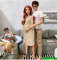 a man and woman standing next to each other in front of a couch with toys