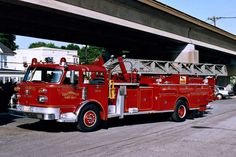 a red fire truck parked in front of a bridge