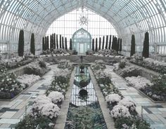 the inside of a building with lots of plants and flowers in it's center