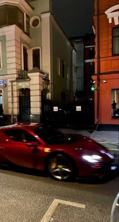 a red sports car is parked on the side of the road in front of some buildings