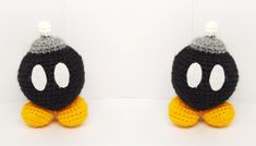 two black and white crocheted stuffed animals with yellow feet, one is wearing a hat