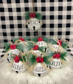 christmas ornament set with pine cones and red berries hanging from the top on a black and white checkered tablecloth