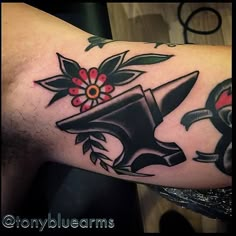 a man's arm with an old school style tattoo on it, featuring a hat and flowers