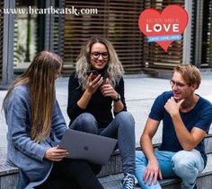 three people are sitting on the steps and one is looking at her cell phone while another looks at her laptop