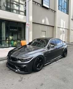 a black car parked in front of a tall building