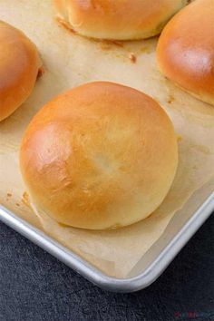 three buns sitting on top of a baking sheet