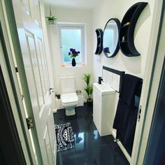 a black and white bathroom with two mirrors on the wall