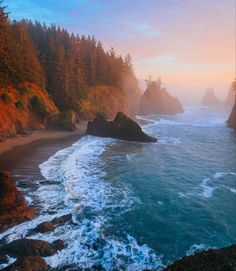 an ocean view with waves crashing on the shore and trees in the background at sunset