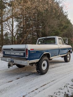 a blue and white truck parked in the snow