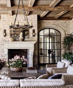 a living room filled with furniture and a fire place in front of a stone fireplace