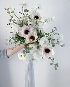 a woman holding a bouquet of white flowers