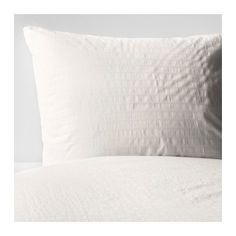 a white pillow sitting on top of a bed