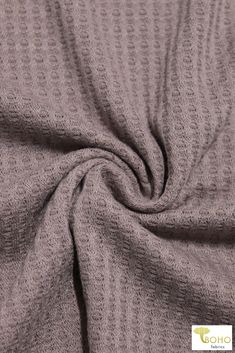 a close up view of a gray sweatering fabric with an interesting pattern on it