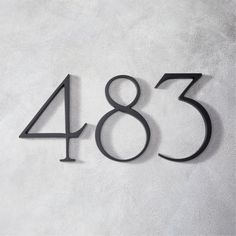 the number eighty three is shown in black on a white background, and it appears to be made out of metal