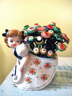 a vase filled with lots of cupcakes on top of a table