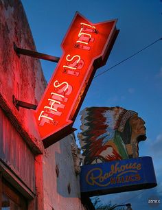 a neon sign that is on the side of a building