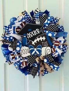 a blue and white wreath with footballs, polka dot bows and a mortar cap on it