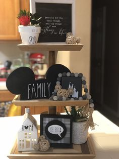 three tiered trays with signs and decorations on top of each other in a kitchen