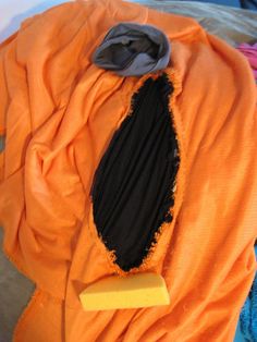 an orange piece of cloth with a black patch on it